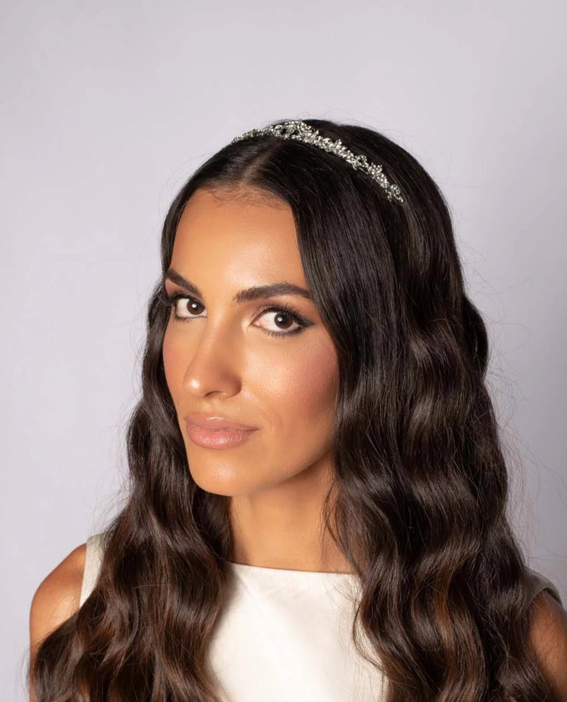 Bride wearing a silver tiara with peaks of sparkling gemstones in a flowing floral pattern