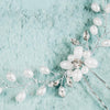 Pearls and crystals hair pin for brides on blue background
